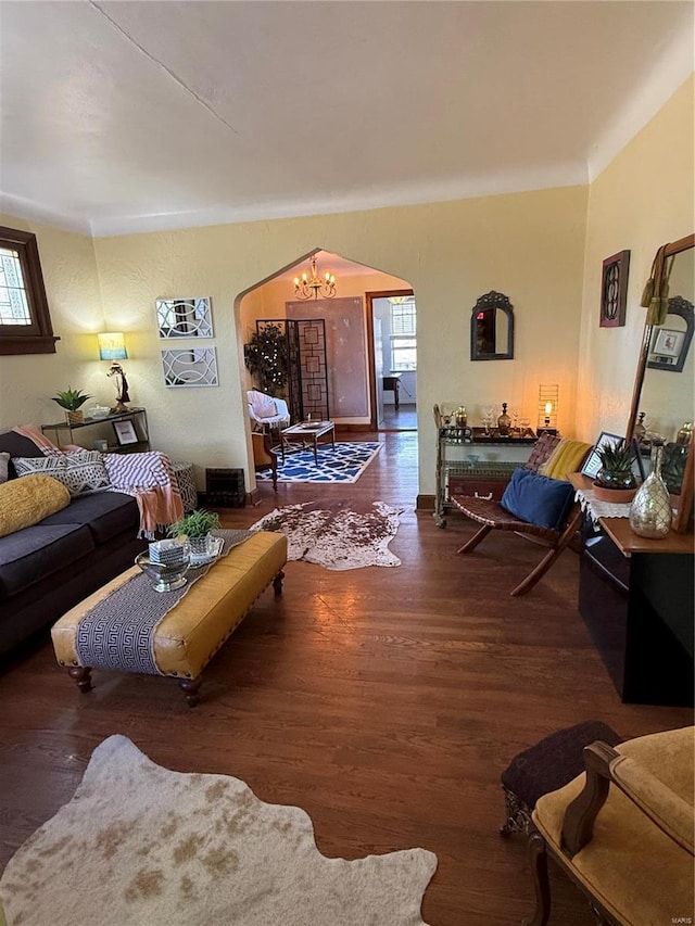 living room with dark hardwood / wood-style flooring and an inviting chandelier