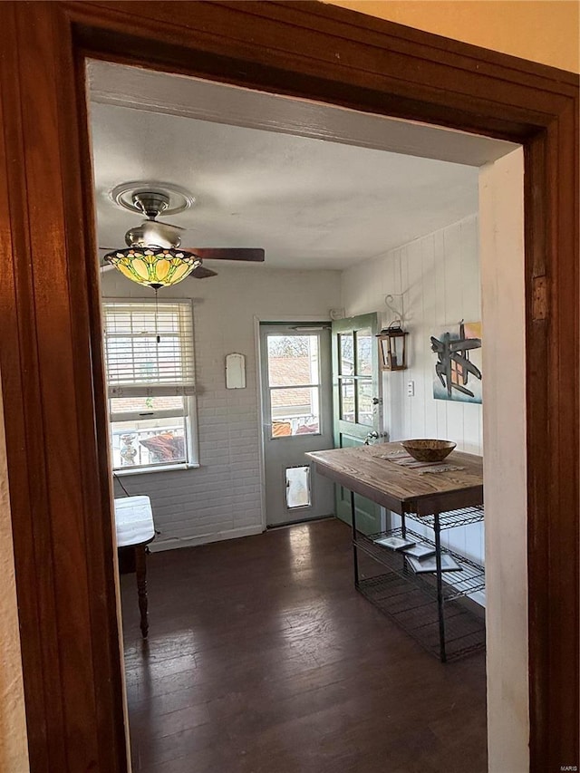 unfurnished dining area featuring dark wood-type flooring and ceiling fan