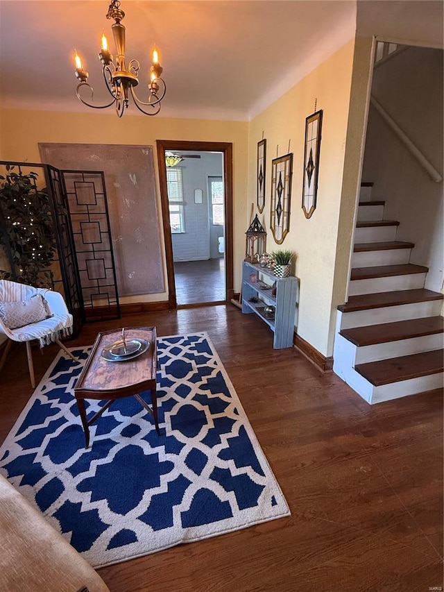 entryway with baseboards, wood finished floors, a chandelier, and stairs