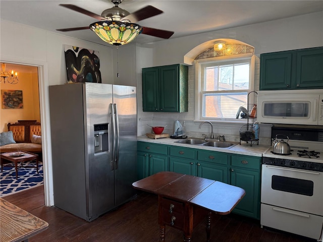 kitchen with a sink, white appliances, dark wood-type flooring, and green cabinetry