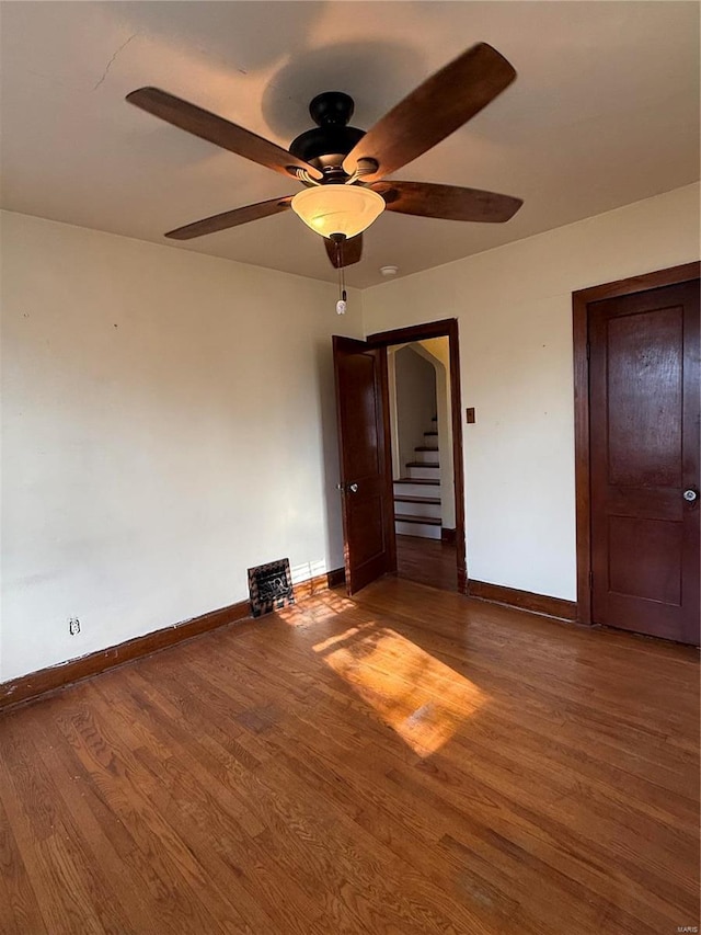 unfurnished bedroom with baseboards, wood finished floors, and a ceiling fan