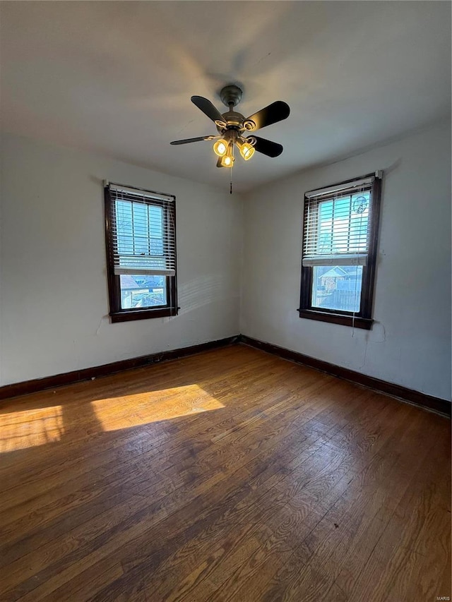 empty room with a ceiling fan, baseboards, and wood-type flooring