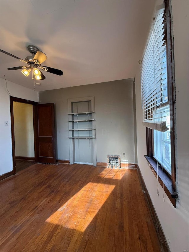 interior space with wood finished floors, baseboards, and ceiling fan