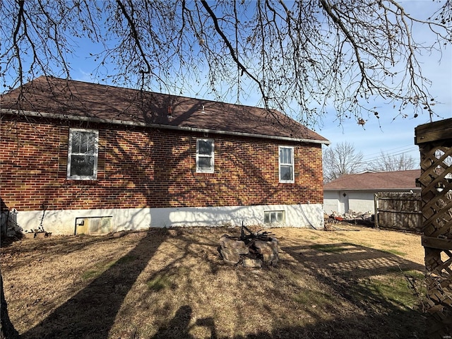 back of property featuring brick siding and fence