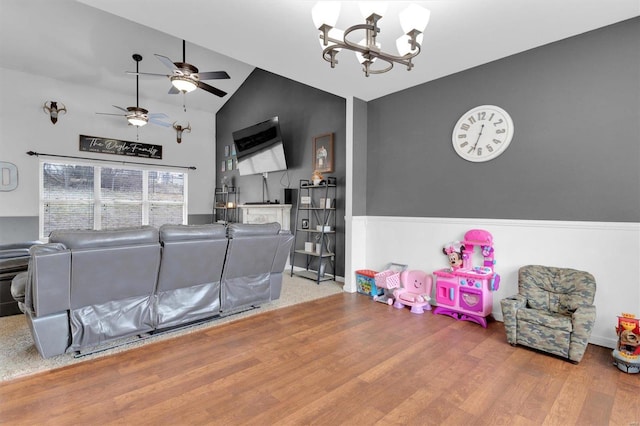 living room featuring hardwood / wood-style flooring, ceiling fan with notable chandelier, and high vaulted ceiling