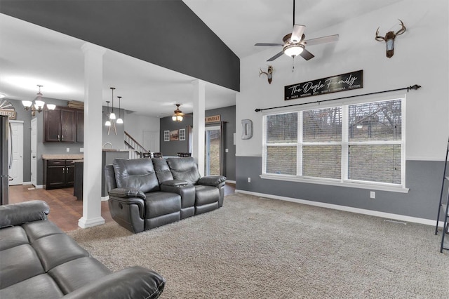 living room with high vaulted ceiling, dark colored carpet, ceiling fan, and ornate columns