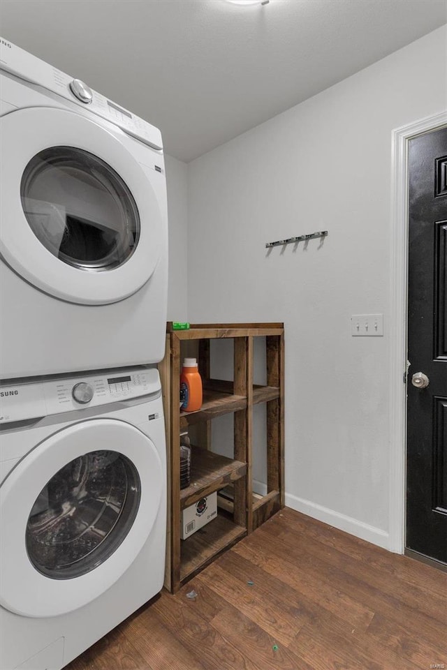 washroom featuring dark wood-type flooring and stacked washing maching and dryer