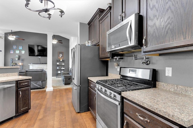 kitchen featuring ceiling fan, appliances with stainless steel finishes, dark brown cabinets, decorative columns, and light hardwood / wood-style floors