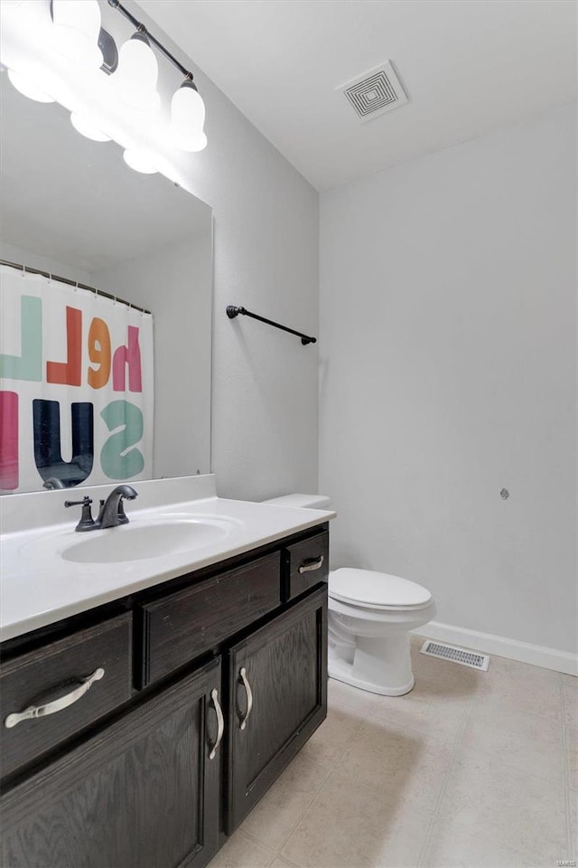 bathroom featuring tile patterned flooring, vanity, and toilet