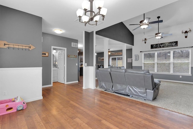 living room featuring hardwood / wood-style flooring, lofted ceiling, and ceiling fan with notable chandelier