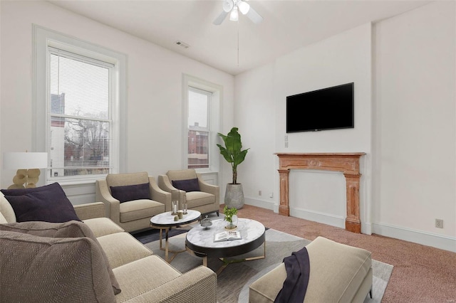 carpeted living room featuring visible vents, a ceiling fan, and baseboards