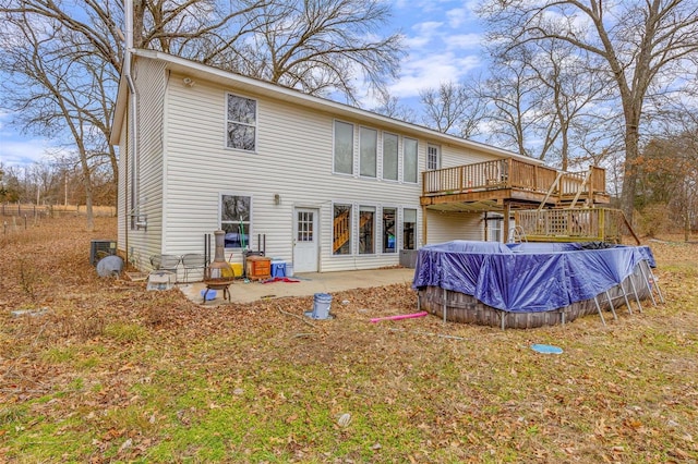 back of house featuring a swimming pool side deck, cooling unit, and a patio area