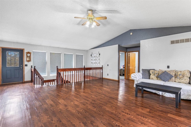 living room featuring vaulted ceiling, dark wood-type flooring, ceiling fan, and a textured ceiling