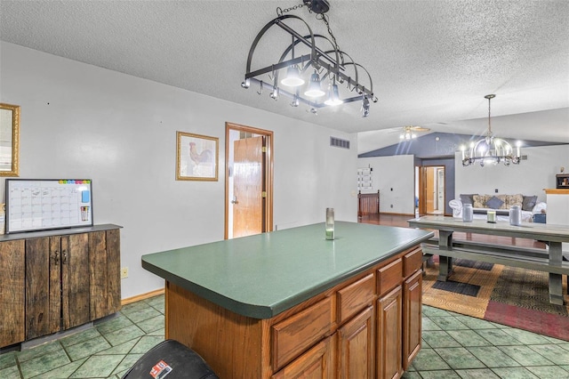 kitchen featuring lofted ceiling, hanging light fixtures, a center island, a textured ceiling, and an inviting chandelier