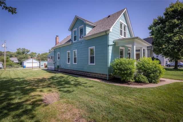 view of side of home featuring an outbuilding, a yard, and a garage