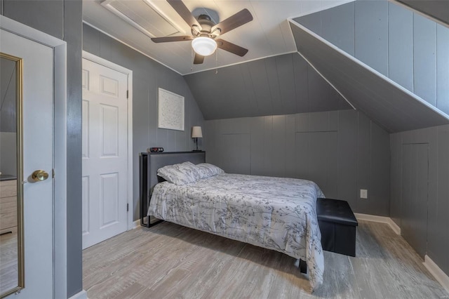 bedroom featuring ceiling fan, lofted ceiling, and light wood-type flooring