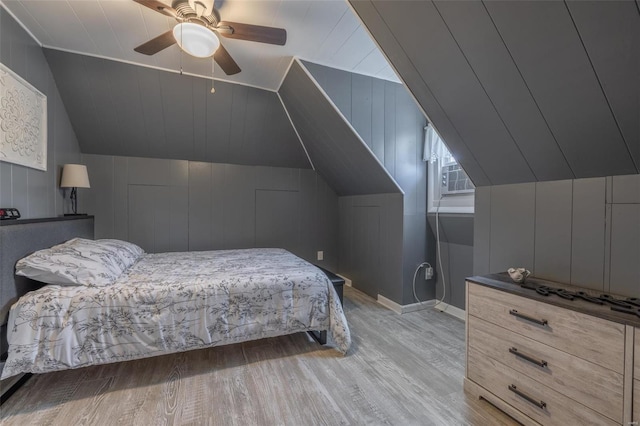 bedroom with ceiling fan, lofted ceiling, and light hardwood / wood-style floors