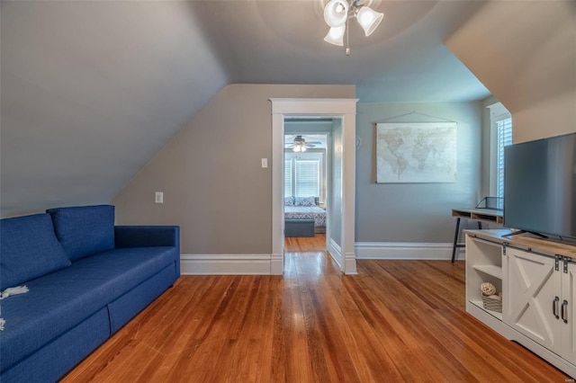 living room with ceiling fan, lofted ceiling, and light hardwood / wood-style floors