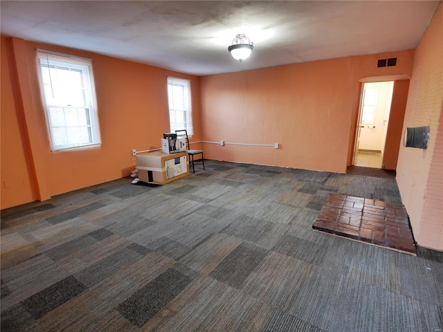 unfurnished room with dark colored carpet