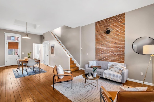 living area with stairway, baseboards, and hardwood / wood-style flooring