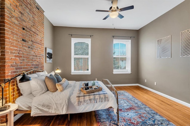 bedroom featuring ceiling fan, wood finished floors, and baseboards