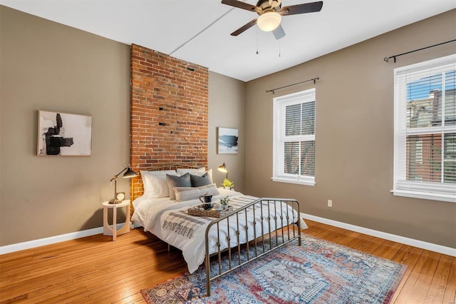 bedroom with hardwood / wood-style flooring, baseboards, and a ceiling fan