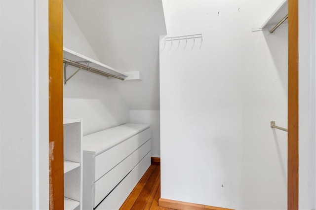 spacious closet with lofted ceiling and wood finished floors