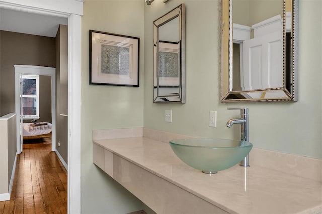 bathroom with connected bathroom, baseboards, hardwood / wood-style floors, and vanity