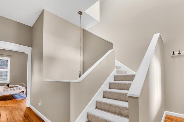 staircase with baseboards and wood finished floors