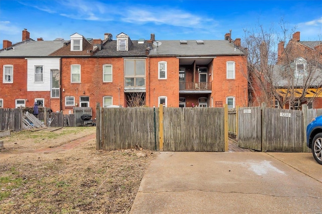 exterior space with a chimney, fence, and brick siding