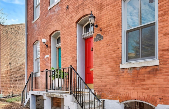 doorway to property featuring brick siding