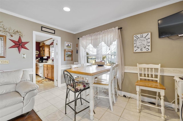 dining area with crown molding and light tile patterned floors