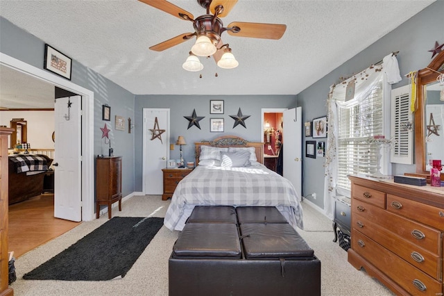 carpeted bedroom with ceiling fan and a textured ceiling