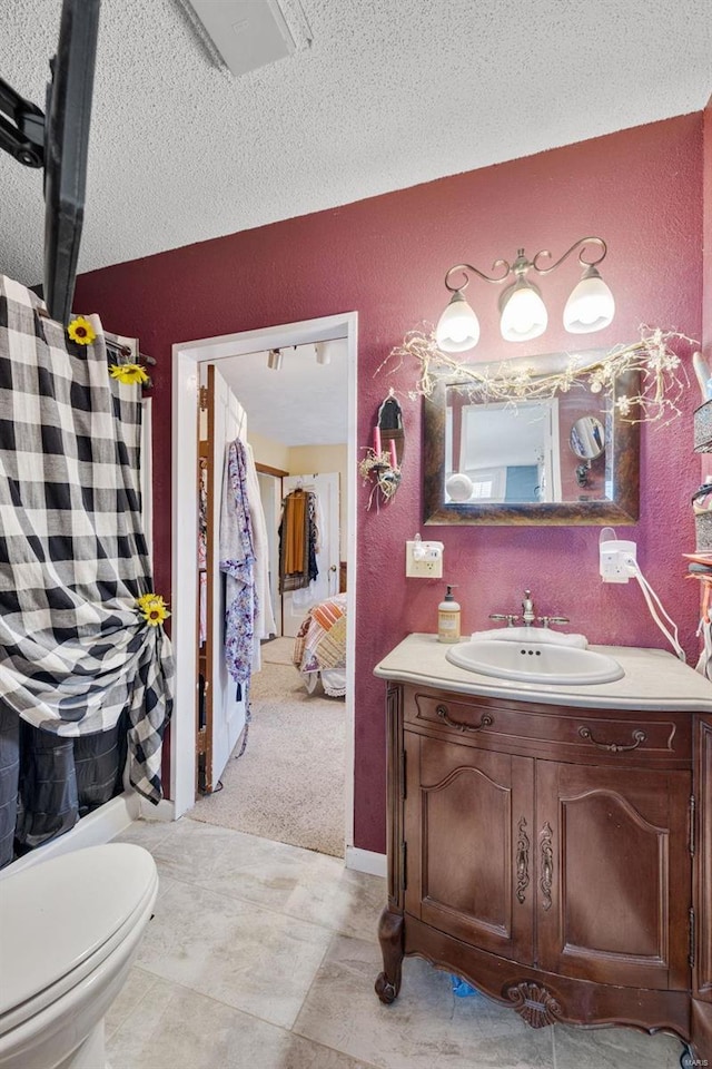 bathroom featuring vanity, a textured ceiling, and toilet