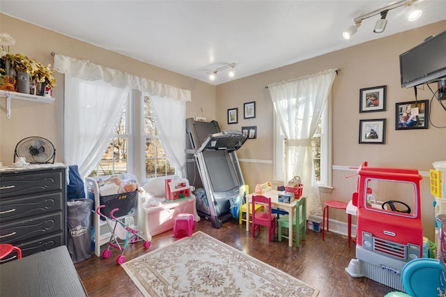 playroom featuring dark wood-type flooring and rail lighting