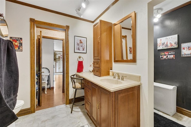 bathroom featuring ornamental molding, vanity, and toilet