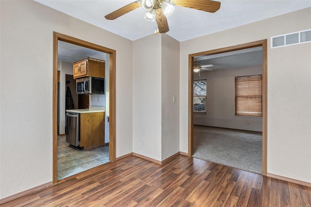 spare room featuring dark wood-type flooring and ceiling fan