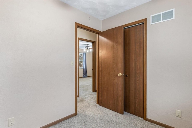 hall with light colored carpet