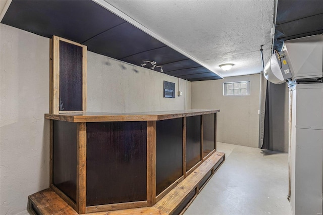 bar with concrete flooring and a textured ceiling