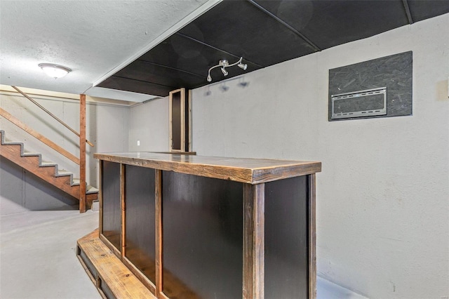 bar featuring concrete flooring and a textured ceiling