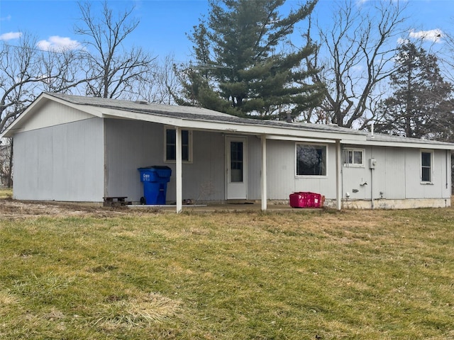 rear view of property featuring a lawn