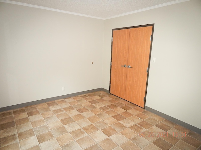 spare room featuring ornamental molding and a textured ceiling