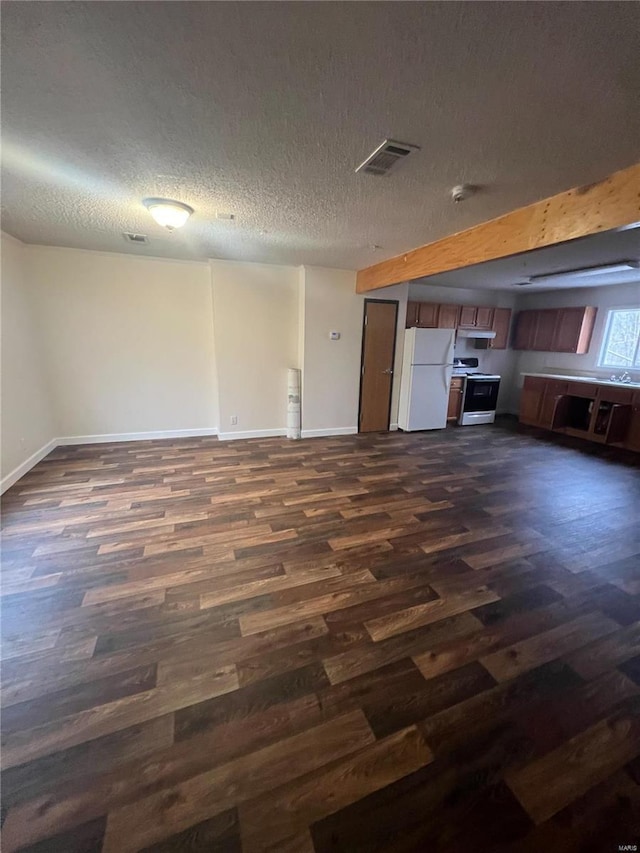 kitchen with white appliances, dark hardwood / wood-style floors, and a textured ceiling