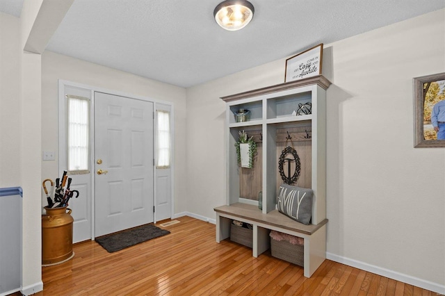 mudroom featuring light wood finished floors and baseboards