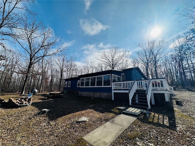 view of front facade with a wooden deck and a sunroom