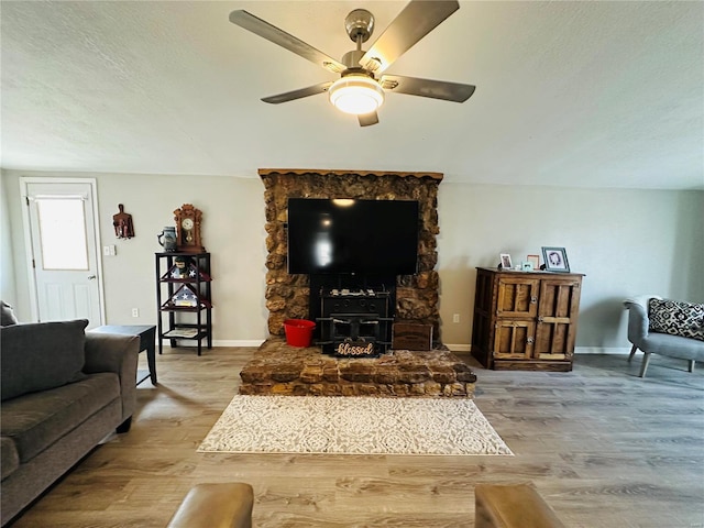 living room with ceiling fan, wood-type flooring, and a textured ceiling