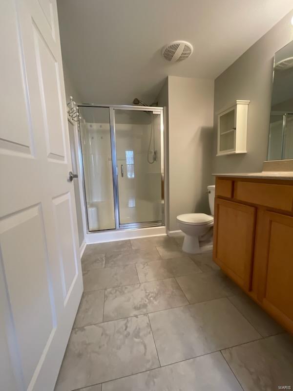 bathroom with vanity, toilet, and walk in shower