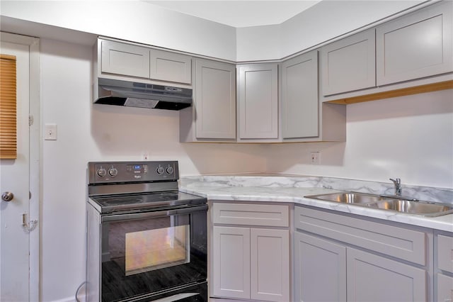 kitchen with sink, light stone countertops, black electric range, and gray cabinetry