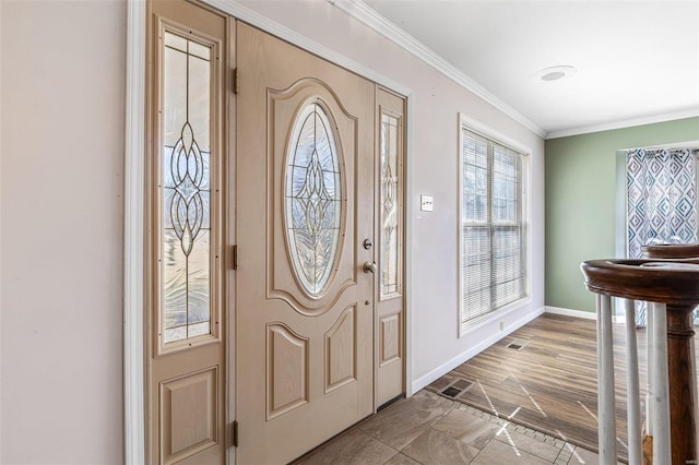 foyer entrance with ornamental molding and hardwood / wood-style floors