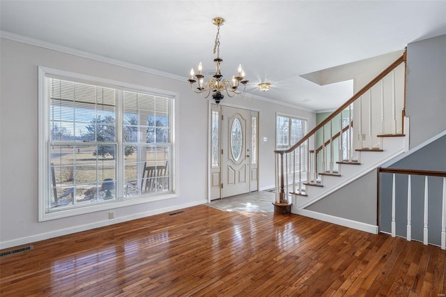 entrance foyer featuring an inviting chandelier, hardwood / wood-style floors, and ornamental molding